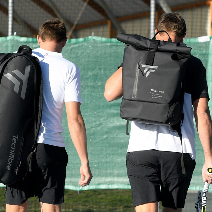 Photo de deux joueurs de tennis sur un playground avec chacun un sac a dos Tecnifibre concu par Tweener, expert du design textile.